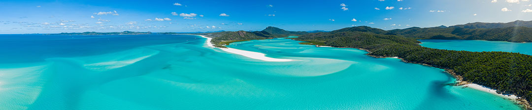 Blue skys, clear water, white sand and mountains in the background