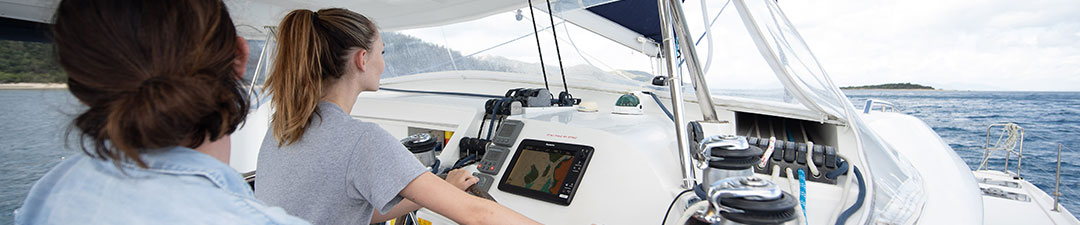 Woman in the cockpit steering a boat