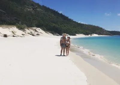 Couple on the beach near the water with mountain behind them