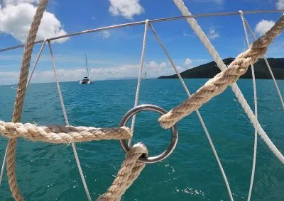 View of the water and sail boats through some ropes