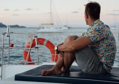 Man sitting on the deck looking out at other boats