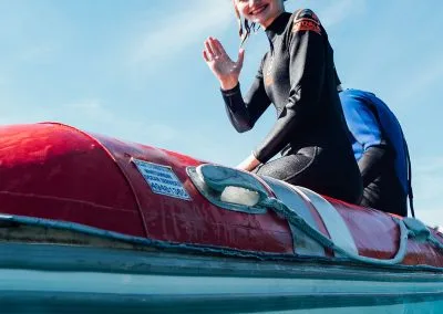 Woman waving down from dinghy